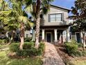 Two-story house with a blue door and landscaped yard at 28489 Tranquil Lake Cir, Wesley Chapel, FL 33543