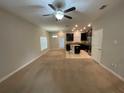 Open living room with kitchen and access to backyard at 28489 Tranquil Lake Cir, Wesley Chapel, FL 33543