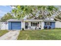 Cute blue and white ranch home with a covered porch and spacious yard at 3303 Bainbridge Dr, Holiday, FL 34691