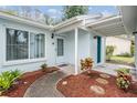 Front entrance with teal door and well-maintained landscaping at 3510 Dellefield St, New Port Richey, FL 34655