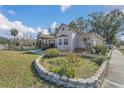 House with a landscaped yard, stone wall accents, and mature trees at 37620 Howard Ave, Dade City, FL 33525