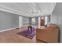 Bright living room featuring hardwood floors, gray walls, and a ceiling fan at 37620 Howard Ave, Dade City, FL 33525