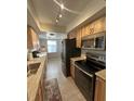 Galley kitchen with stainless steel appliances and wood cabinets at 4498 Lake Blvd, Clearwater, FL 33762