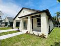 Charming single-story home featuring a covered porch, white brick, dark trim, and well-maintained landscaping at 5701 N 20Th St, Tampa, FL 33610