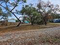 Wooded lot with gravel driveway and neighboring homes at 6274 Boatwrite Rd, Spring Hill, FL 34609