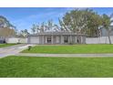 Gray house with white shutters, attached garage, and manicured lawn at 6543 Spanish Moss Cir, Tampa, FL 33625