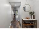 Bright hallway with wood-look floors and a stylish entry table at 8703 Bardmoor Blvd # 106, Seminole, FL 33777