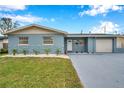 Newly renovated light blue house with a neatly landscaped front yard at 9100 52Nd N Way, Pinellas Park, FL 33782