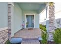 Front entrance with a teal door and brick columns at 935 Signet Dr, Apollo Beach, FL 33572