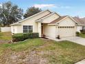 One-story house featuring a two-car garage, neat landscaping and a spacious driveway at 9551 Jaybird Ln, Land O Lakes, FL 34638