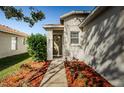 Inviting front entrance with landscaping and a wreath on the door at 9607 Maxson Dr, Land O Lakes, FL 34638