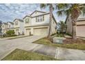 Two-story townhome with a two-car garage, driveway and palm trees at 4762 White Sanderling Ct, Tampa, FL 33619