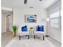 Bright living room with two gray chairs, blue pillows, and a large window at 10463 118Th Ave, Largo, FL 33773