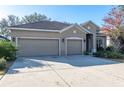 Three-car garage house with a tan exterior at 10721 Rockledge View Dr, Riverview, FL 33579