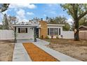 Newly renovated home with a stylish exterior, landscaping, and a paved driveway at 303 E 120Th Ave, Tampa, FL 33612