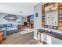 Open living room with wood floors, gray sofa, modern decor, and a view of the dining area and front entrance at 3075 Rosery Ne Rd, Largo, FL 33771