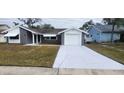 Newly painted house exterior with gray stone, white accents and a long driveway at 4024 Jib Sail Ct, New Port Richey, FL 34652