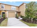 Townhome exterior showcasing a two-car garage and well-maintained landscaping at 4409 Winding River Way, Land O Lakes, FL 34639