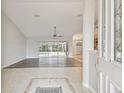 Spacious living room featuring wood floors, ceiling fan, and sliding glass doors to the pool at 4534 Cozzo Dr, Land O Lakes, FL 34639