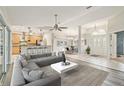 Open-concept living room with modern gray sofa, chandelier, and dining area at 4534 Cozzo Dr, Land O Lakes, FL 34639