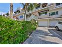 Front view of townhouse with private driveway and well-maintained landscaping at 4625 Mirabella Ct, St Pete Beach, FL 33706