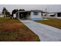 Front view of a mobile home with a driveway and landscaping at 5341 Mary St, Zephyrhills, FL 33542