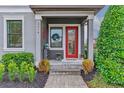 Inviting front porch with a red door, wreath, and stone walkway at 5716 Colony Glen Rd, Lithia, FL 33547