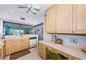 Kitchen with light wood cabinets, appliances, and workspace at 6051 Sun Blvd # 207, St Petersburg, FL 33715