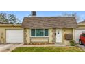 Front view of a single-story house with a garage and well-maintained lawn at 8330 Vendome N Blvd, Pinellas Park, FL 33781