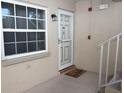 Condo entry with white door and screen door, next to window at 948 Virginia St # 110, Dunedin, FL 34698