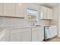 White cabinets, quartz countertops, stainless steel dishwasher and hexagon backsplash at 9801 Crescent Moon Dr, Riverview, FL 33578