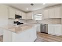 Modern kitchen featuring white cabinets, quartz countertops, and stainless steel appliances at 9801 Crescent Moon Dr, Riverview, FL 33578