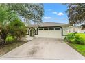 House exterior with a white garage door and landscaping at 10186 Sleepy Willow Ct, Spring Hill, FL 34608