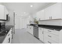 Modern kitchen with white cabinets, black countertops, and stainless steel appliances at 18292 Robinson Ave, Port Charlotte, FL 33948