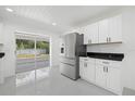 Modern kitchen with white cabinets, black countertops, and stainless steel appliances at 18292 Robinson Ave, Port Charlotte, FL 33948