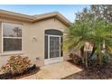 Front entrance with screen door, landscaping, and a small American flag at 2028 Acadia Greens Dr, Sun City Center, FL 33573