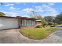White garage door and side view of a brick ranch home at 2320 Shelly Dr # B, Palm Harbor, FL 34684