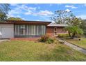 Brick ranch home with a sunroom and well-manicured lawn at 2320 Shelly Dr # B, Palm Harbor, FL 34684