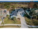 Aerial view of beautiful home with gazebo, backyard bordered by trees, and two-car garage at 2930 Swan Cir, Dunedin, FL 34698