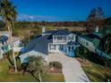 Aerial view of beautiful home with gazebo, backyard bordered by trees, and two-car garage at 2930 Swan Cir, Dunedin, FL 34698