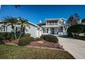 Charming two-story home features a lovely front porch and balcony, landscaped yard and long driveway at 2930 Swan Cir, Dunedin, FL 34698