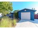Charming blue house with a star detail, landscaping, and attached garage at 3628 Holiday Lake Dr, Holiday, FL 34691