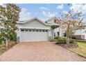 Two-story house with gray siding, red door, and brick paver driveway at 5613 Del Coronado Dr, Apollo Beach, FL 33572