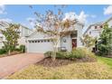 Two-story home with gray siding, brick driveway, and landscaping at 5613 Del Coronado Dr, Apollo Beach, FL 33572