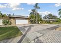 Home with white garage door and brick paver driveway at 775 Rolling Hills Dr, Palm Harbor, FL 34683