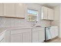 White kitchen with hexagon tile backsplash and stainless steel dishwasher at 9804 Crescent Moon Dr, Riverview, FL 33578