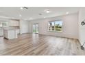 Bright living room with vinyl plank flooring and sliding glass doors to backyard at 9804 Crescent Moon Dr, Riverview, FL 33578