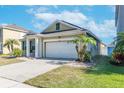 Tan house with white garage door and palm trees at 11536 Tangle Stone Dr, Gibsonton, FL 33534