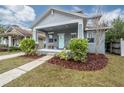 Gray craftsman home with a light teal door, landscaping, and a walkway at 117 W Minnehaha St, Tampa, FL 33604