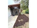 View of a screened porch with a door and landscaping at 2200 Shelly Dr # C, Palm Harbor, FL 34684